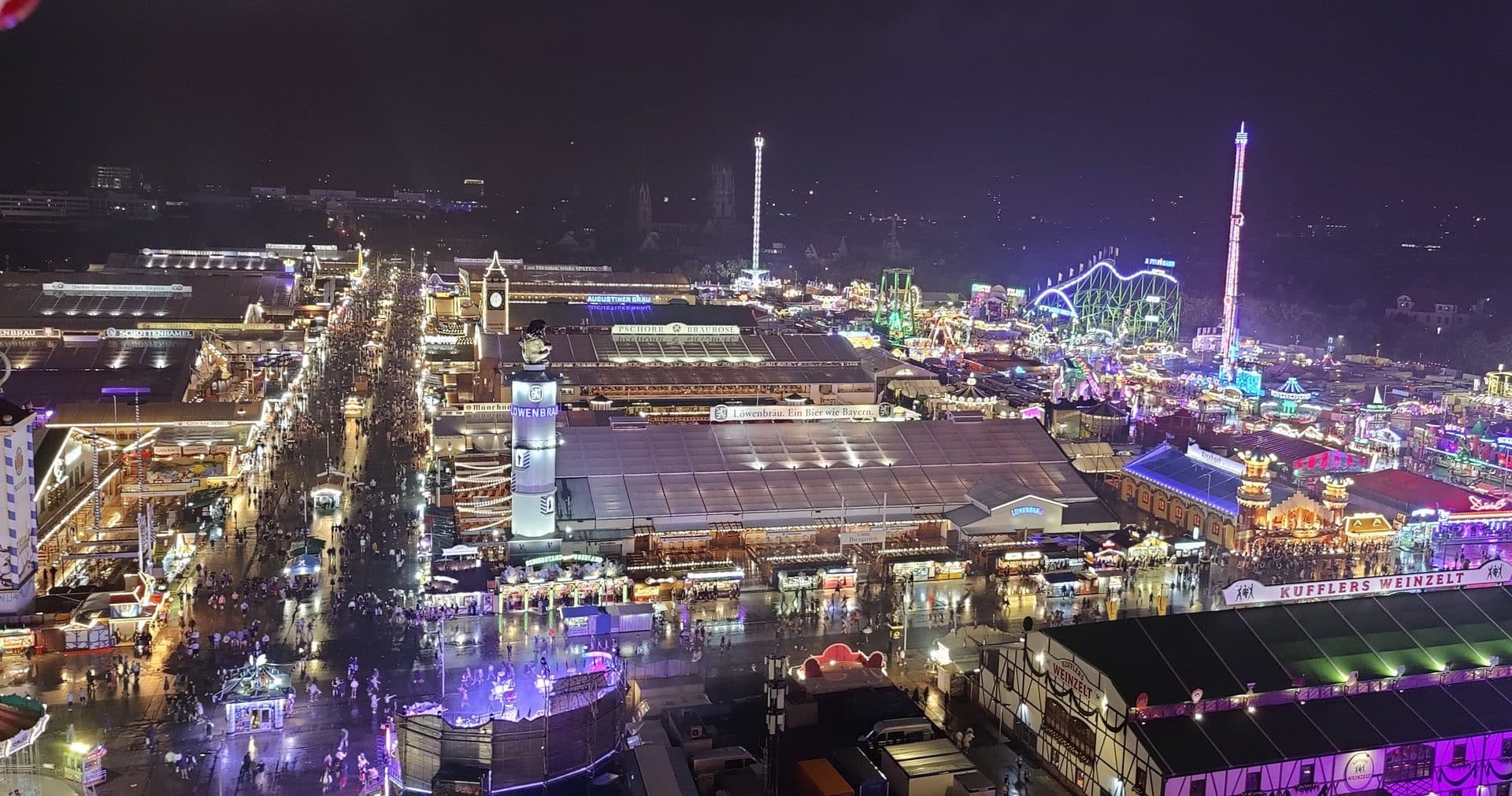 The Oktoberfest grounds lit up at night, seen from the Ferris wheel