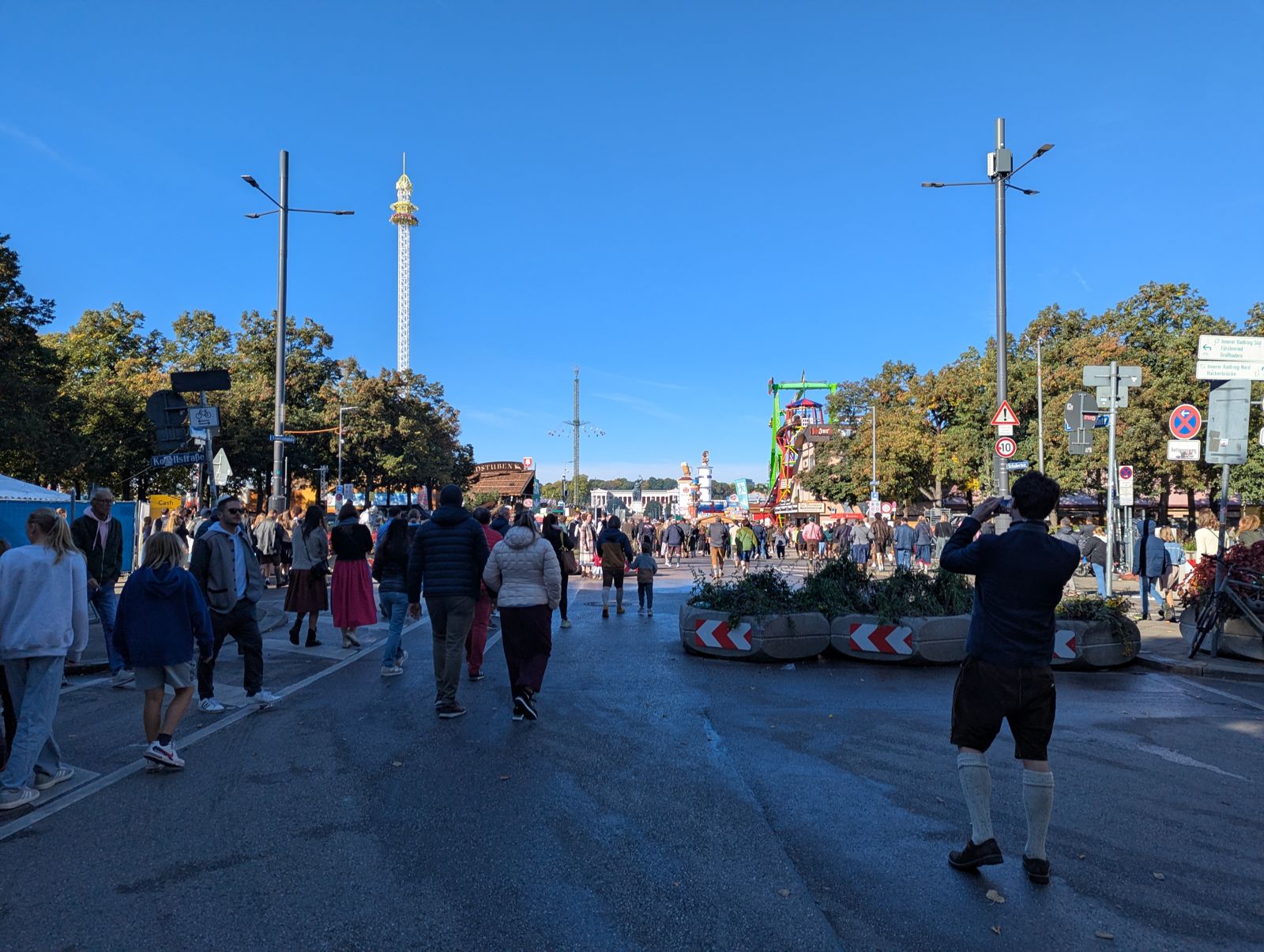A quiet Oktoberfest avenue mid-morning with only a few visitors under a blue sky