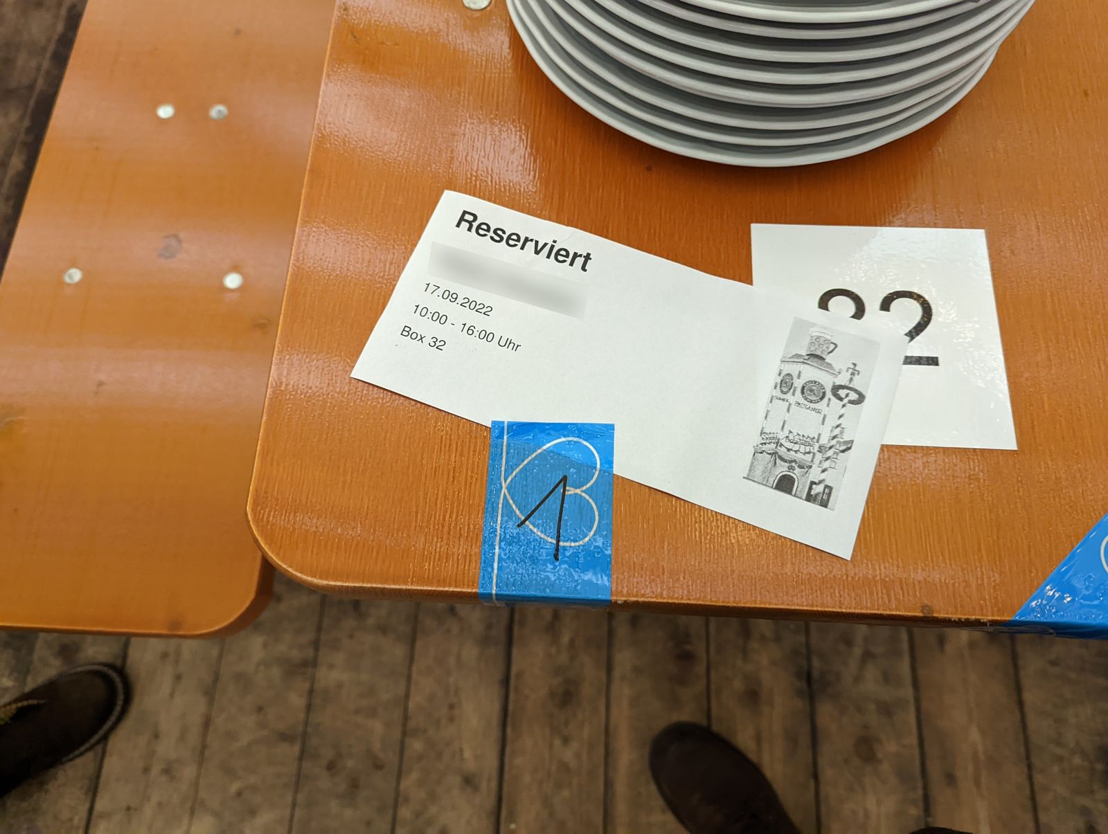 A Reserviert card on a Paulaner Festzelt table showing the date, a 10:00 to 16:00 slot and Box 32