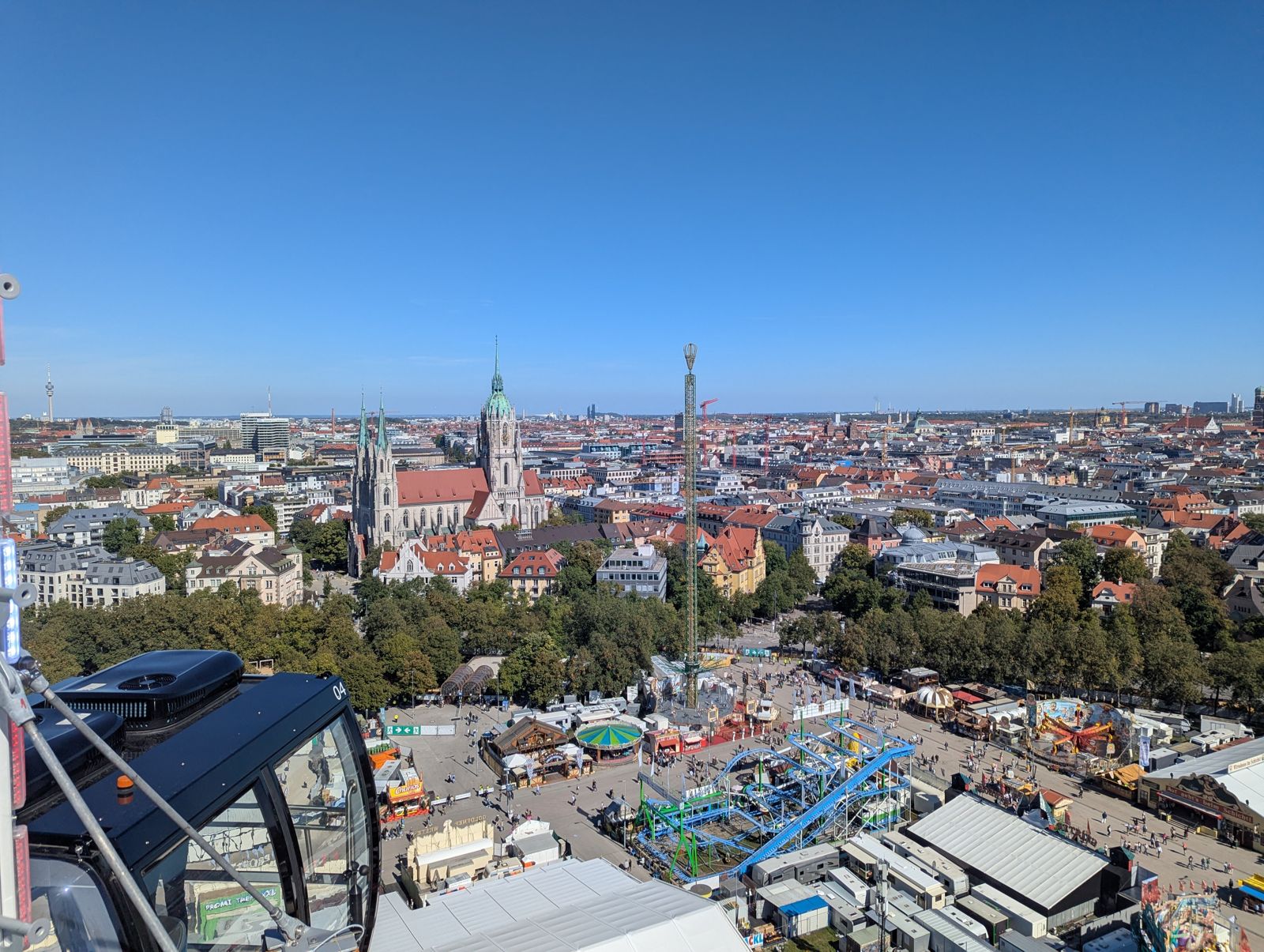 Aerial view over the Oktoberfest grounds towards the Munich skyline and Paulskirche