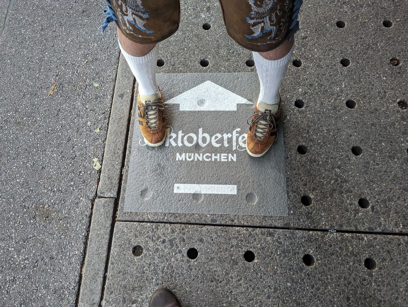 Haferl shoes and white socks below lederhosen on an Oktoberfest München ground plaque